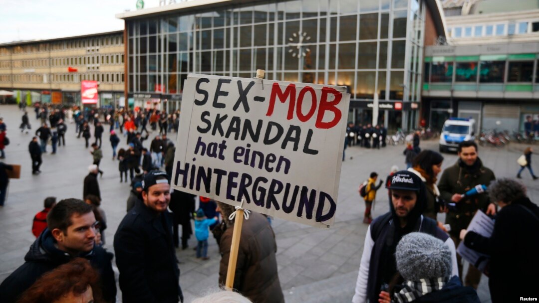 A person holds up a placard reading 'The sex mob scandal has a background' prior to a Patriotic Europeans Against the Islamisation of the West (PEGIDA) demonstration march in front of the main train station in Cologne, Germany, Jan. 9, 2016. 