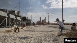 Iranian laborers work at a unit of South Pars gas field in Asalouyeh Seaport, north of Persian Gulf, Iran, Nov. 19, 2015. China's state-owned CNPC energy company now owns 80 percent of the project's share after Total dropped out because of U.S. sanctions.