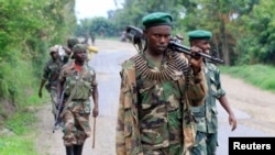 Congolese M23 rebels carry their weapons as they patrol near Rushuru, in Democratic Republic of Congo, Aug. 3, 2013.