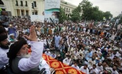 FILE - Khadim Hussain Rizvi, leader of Tehrik-e-Labaik Pakistan (TLP) Islamic political party, gestures as he addresses the supporters during a rally to express solidarity with the people of Kashmir, in Lahore, Pakistan, Aug. 9, 2019.