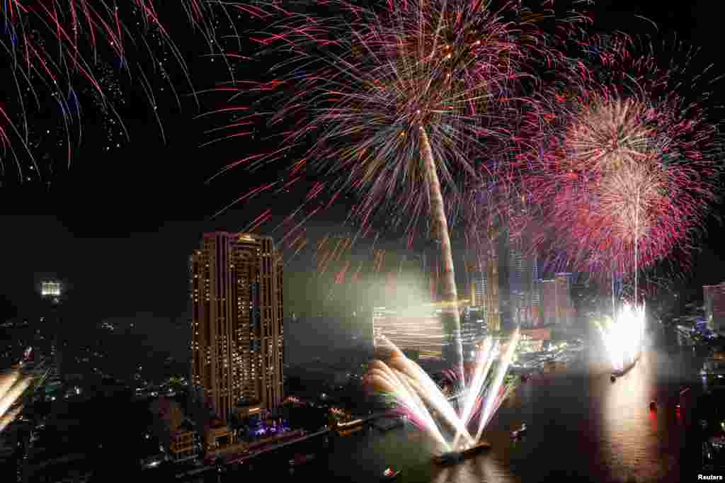 Fireworks explode over Chao Phraya River during the New Year's celebrations in Bangkok, Thailand.