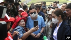 A supporter takes a selfie with former Thai Prime Minister Thaksin Shinawatra, center, at Rajapruek Royal Park in Chiang Mai province, Thailand, March 14, 2024. Thaksin began his first public appearances since leaving detention.