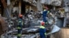 Ukrainian emergency service personnel work outside a damaged building following shelling, in Kharkiv, Ukraine, Saturday, June 4, 2022.