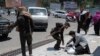 A Taliban fighter searches the belongings of a pedestrian along a blocked street ahead of a council meeting of tribal and religious leaders in Kabul, June 29, 2022.