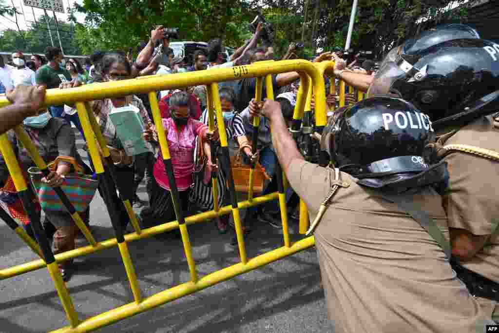 Activists from Samagi Vanitha Balawegaya, a part of the main opposition party Samagi Jana Balawegaya, overturn a police barricade during a protest outside Sri Lanka's Prime Minister Ranil Wickremesinghe's private residence in Colombo, amid the country's economic crisis.