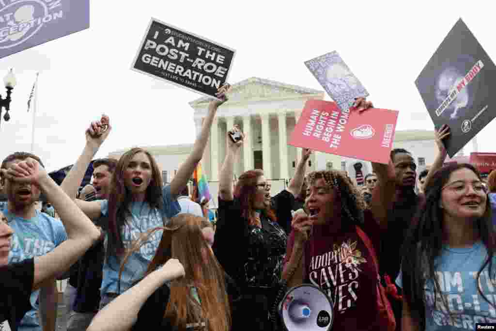 Un grupo de mujeres celebran la decisión a las afueras de la Corte Suprema. "Los derechos humanos comienzan en el útero", dice uno de sus carteles. 