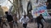 A protester throws stones as others run for cover during clashes with riot police at Tahrir Square in Cairo, November 26, 2012. 