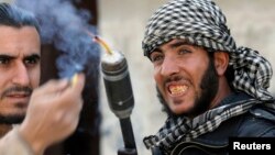 Rebeldes sirios combaten a tropas gubernamentales en un barrio de Damasco.