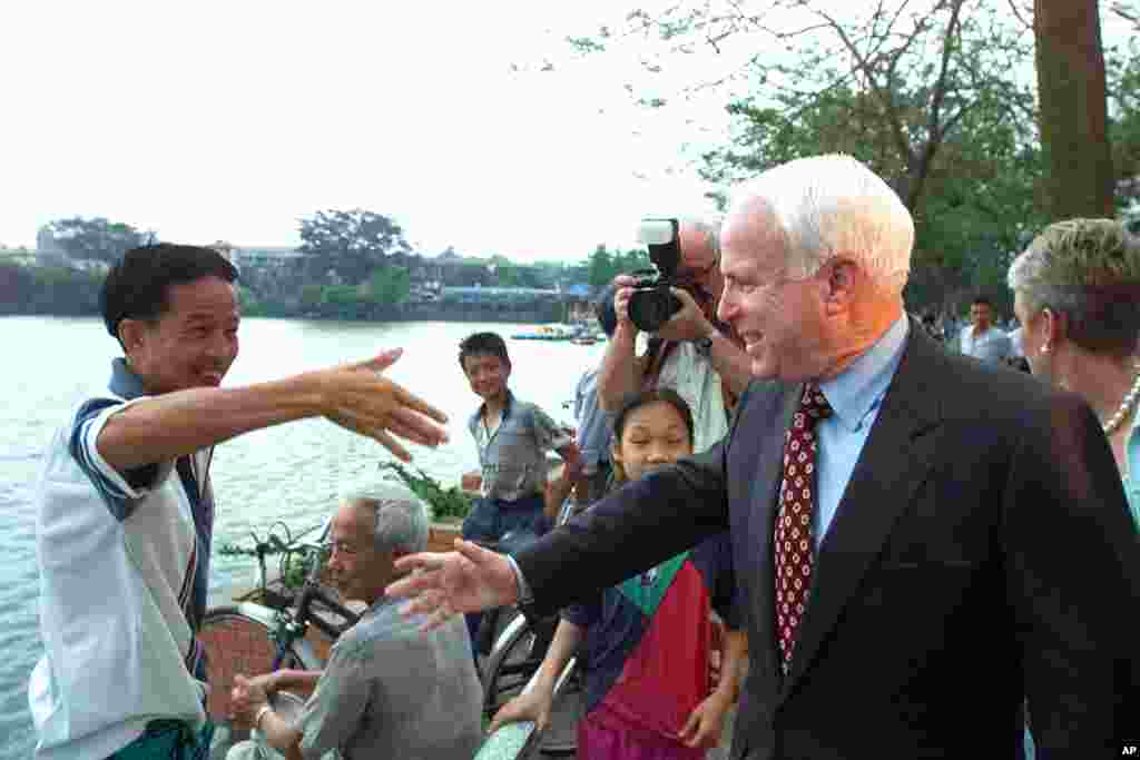 Thượng nghị sĩ John McCain bắt tay chào một người dân trên bờ hồ Trúc Bạch ở Hà Nội, ngày 26 tháng 4 năm 2000. “Kiểm tra tình trạng bức tượng của tôi lúc nào cũng là điều tốt,” ông nói với phóng viên của AP, nhắc tới tấm bia dựng tại hồ này kỉ niệm sự kiện ông bị bắn rơi vào năm 1967. “Đó là bức tượng duy nhất mà tôi có,” ông nói và cười tươi. Chuyến đi Việt Nam này của ông diễn ra không lâu sau khi ông rút khỏi cuộc đua giành đề cử tổng thống của Đảng Cộng hòa vào đầu tháng 3 sau những thất bại liên tiếp trước ứng cử viên đồng đảng George W. Bush.