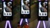 Children use smartphones near monitors displaying a Chinese action movie "Wolf Warrior 2" at a cinema in Beijing, Aug. 10, 2017.