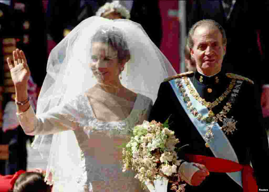 A princesa espanhola, Elena, acena para a multidão, enquanto é levada pelo seu pai, Rei Juan Carlos, ao altar da catedral de Sevilha, Março 18, 1995.