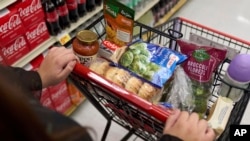 A cart holding groceries is pushed through a supermarket in Bellflower, Calif., on Monday, Feb. 13, 2023.