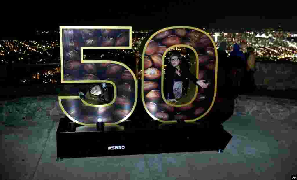 Erika Moya (l), and Ashley King, pose for a photo in a Super Bowl 50 display at a park overlooking San Francisco. The Denver Broncos play the Carolina Panthers in the NFL Super Bowl 50 football game Sunday, Feb. 7, 2015 in Santa Clara, Calif.