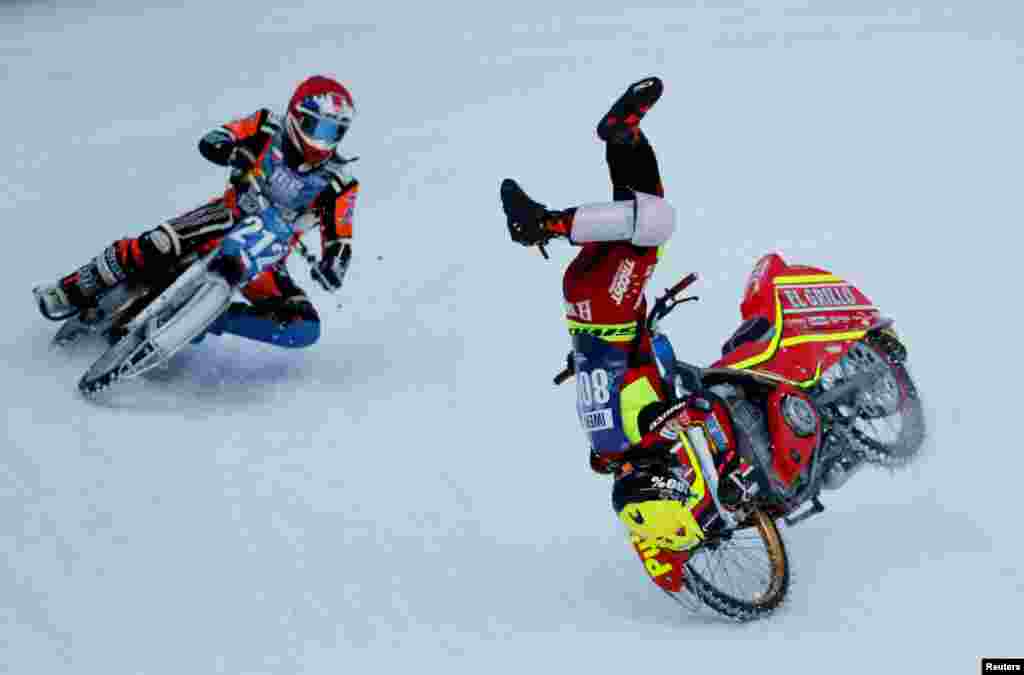 Jasper Iwema of Netherlands falls down while competing with Lukas Hutla of Czech Republic during the final round of the FIM Ice Speedway Gladiators World Championship at the Medeo rink in Almaty, Kazakhstan.