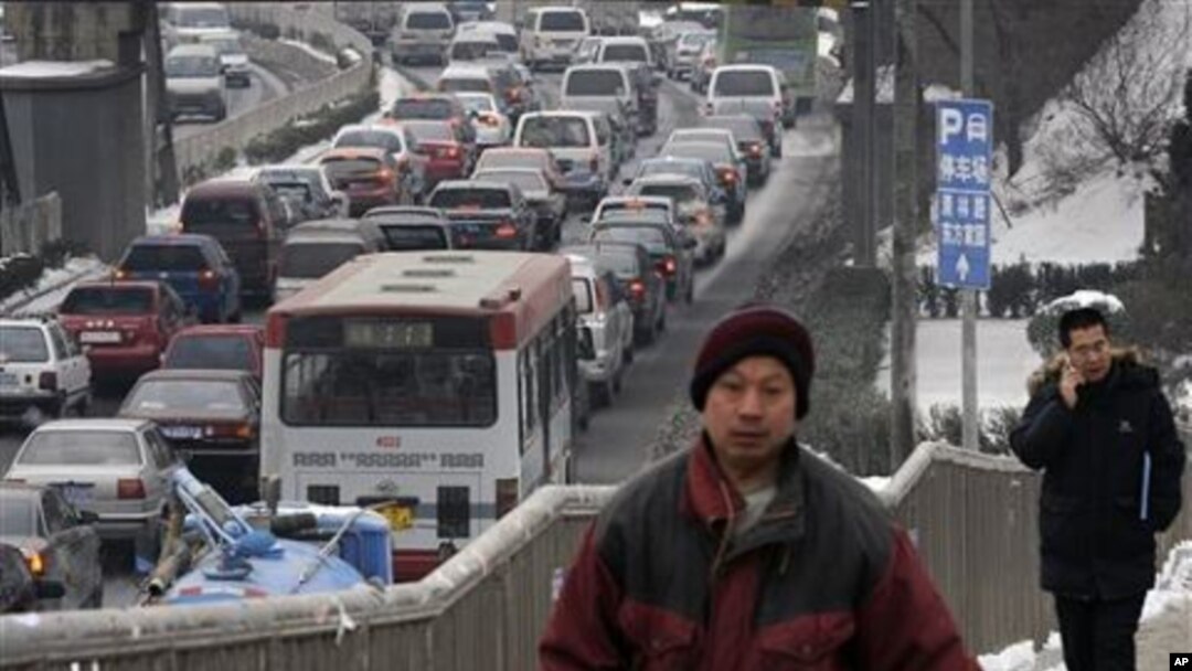 Chinese walk on a pedestrian overhead bridge next to the vehicles driven in heavy traffic in Beijing (File)