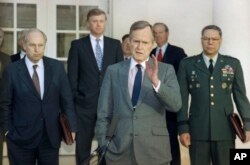 En esta foto de archvio del 11 de febrero de 1991 se ve al presidente George H.W. Bush conversando con periodistas en el Jardín de las Rosas de la Casa Blanca, tras reunirse con altos asesores militares para discutir sobre la Guerra del Golfo. Desde la izquierda: el secretario de Defensa Dick Cheney, el vicepresidente Dan Quayle, el presidente Bush, el secretario de Estado James Baker y el jefe del Estado Mayor Conjunto de las Fuerzas Armadas Colin Powell.