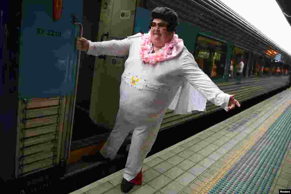 Sean Wright poses for a photo before boarding the Elvis Express, bound for Parkes for the Elvis festival, at Central Station in Sydney, Australia.