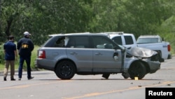 Dua petugas menyelidiki di TKP pasca insiden mematikan di mana sebuah mobil menabrak pejalan kaki di dekat Ozanam Center, tempat perlindungan bagi migran dan tunawisma, di Brownsville, Texas, AS Minggu 7 Mei 2023.