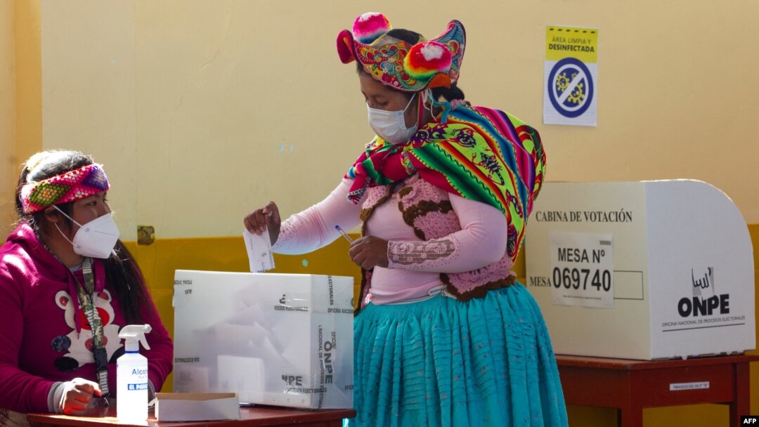 A women wearing traditional quechua attire casts her vote at a polling station in the rural Andean community of Capachica, Peru, June 6, 2021. 