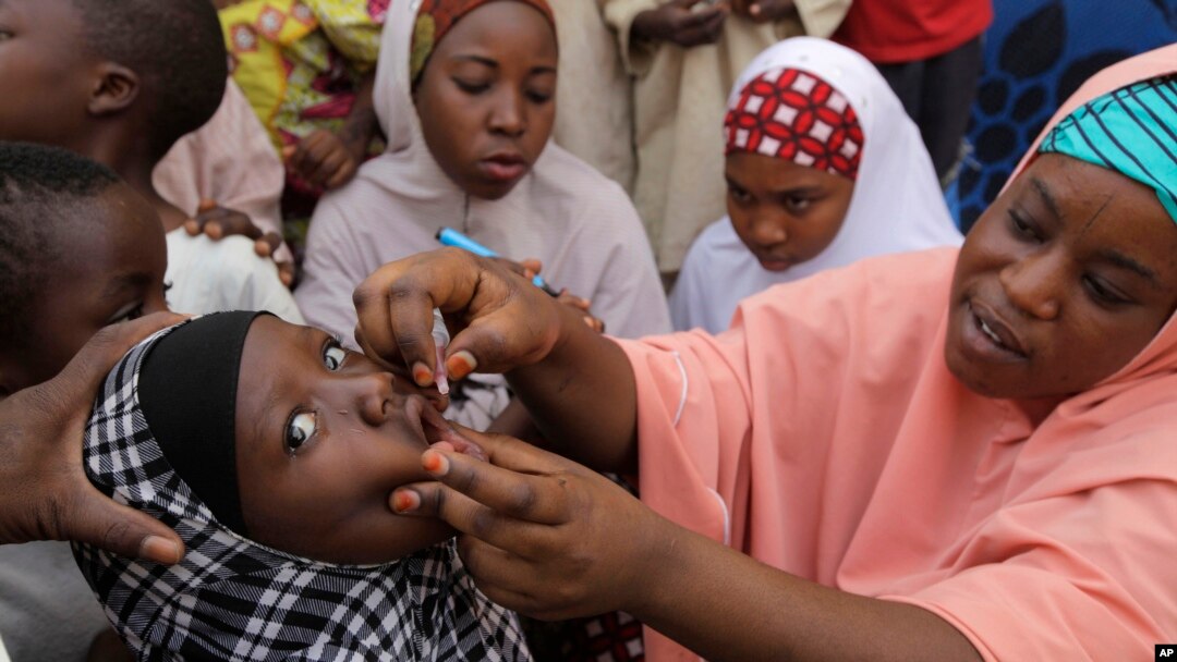 In this 2014 file photo, a health official administers a polio vaccine to a child in Nigeria. Nigeria has reported the first two cases of polio after more than two years -- in an area where Islamic extremists have operated. (AP Photo/ Sunday Alamba)