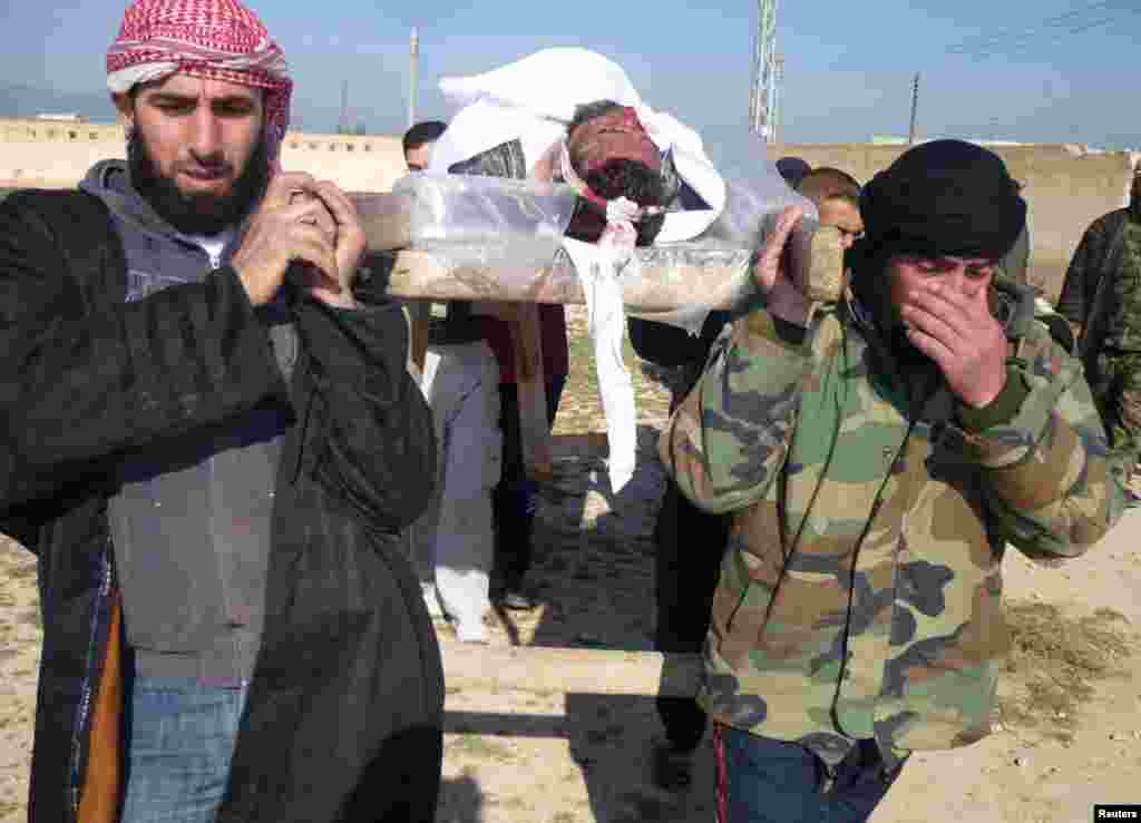 Free Syrian Army fighters carry the body of their comrade who died during clashes with forces loyal to Syria's President Bashar al-Assad, in Qusair town near Homs, March 25, 2013.