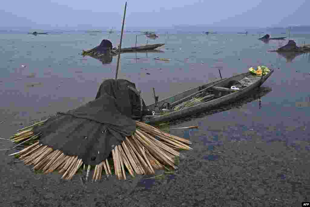 Fishermen catch fish with harpoons near a frozen portion of Anchar Lake in the outskirts of Srinagar, India.