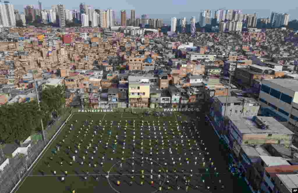 Residents of the Paraisopolis slum attend a ceremony on a soccer field in Sao Paulo, Brazil.