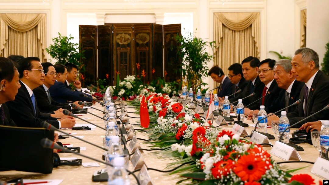 China's Premier Li Keqiang, second left, and Singapore's Prime Minister Lee Hsien Loong, right, attend a meeting with their respective delegations at the Istana or presidential building in Singapore, Nov. 12, 2018.