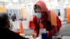 FILE - A young voter fills out a ballot with assistance from a poll worker at a polling station at the Midtown Center shopping mall in Milwaukee, on the first day of in-person voting in Wisconsin, October 20, 2020.