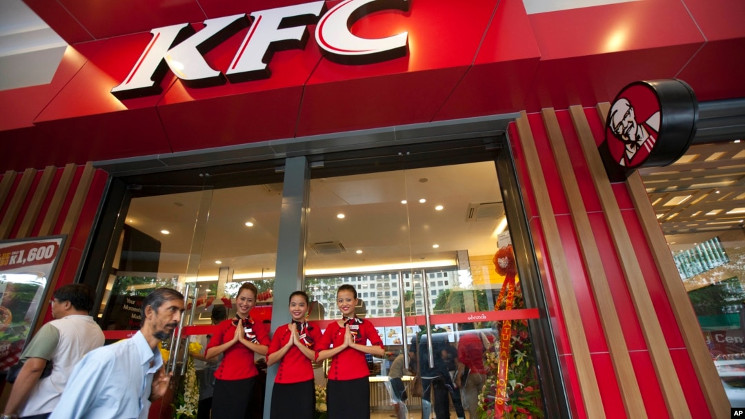 Staff members greet visitors at its grand openning, first branch of Kentucky fried chicken (KFC) restaurant, June 30, 2015, in Yangon, Myanmar.