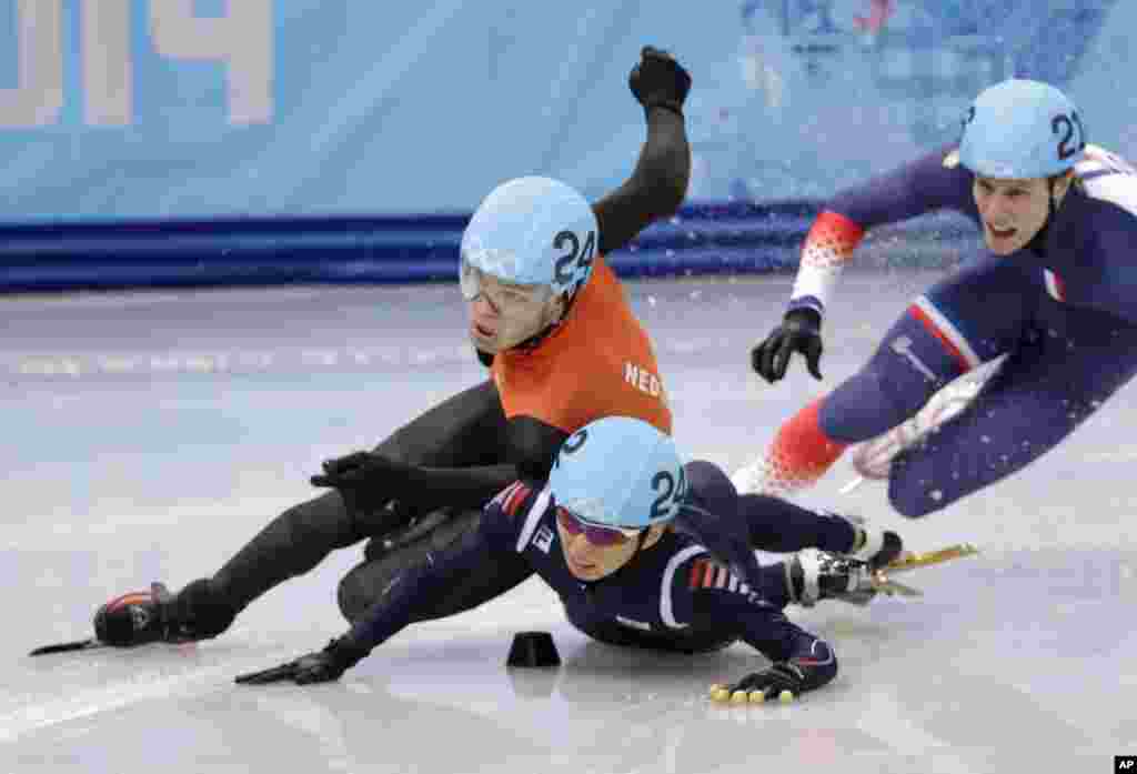 Sjinkie Knegt of the Netherlands, left, and Park Se-Yeong of South Korea crash out as they compete in a men's 1500m short track speedskating final at the Iceberg Skating Palace, Sochi, Russia, Feb. 10, 2014.