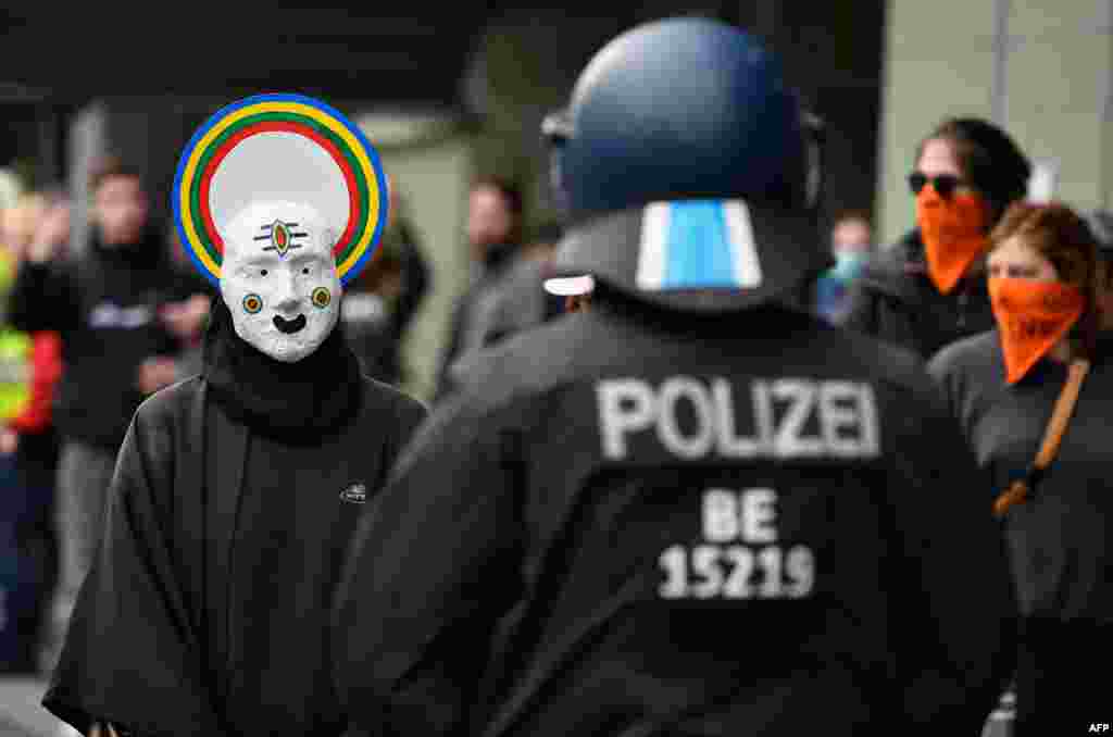 A protester wearing a mask is seen with police during May Day protests amid the COVID-19 outbreak, in Berlin's Kreuzberg district, Germany.