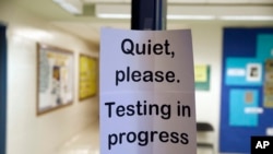 FILE - A sign is posted at the entrance to a hall for a college admission test preparation class in Bethesda, Maryland, Jan. 17, 2016. This year, AP exams are being administered online.