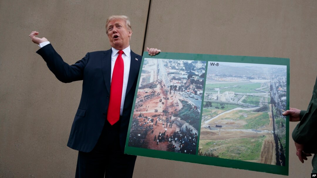 FILE - President Donald Trump talks with reporters as he gets a briefing on border wall prototypes, in San Diego, California, March 13, 2018.
