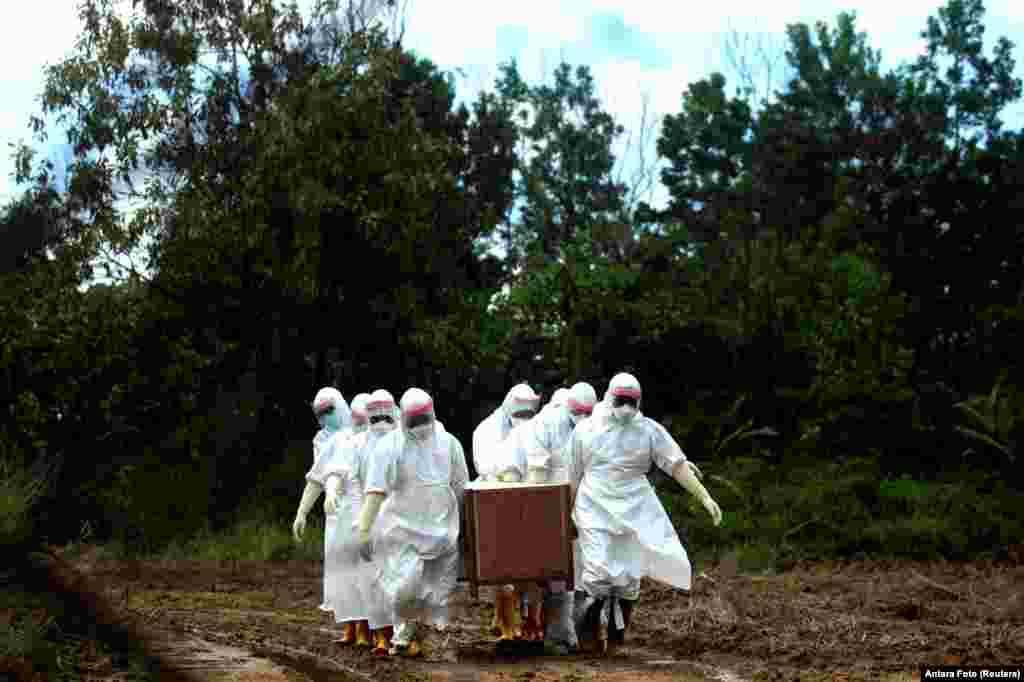 Municipal workers wearing protective gear bury a victim of the coronavirus disease (COVID-19) at a cemetery in Tarakan, North Kalimantan Province, Indonesia.
