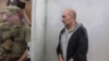 Volodymyr Tsemakh, suspected of involvement in the downing of the Malaysia Airlines Flight MH17 plane in 2014, stands inside a defendants' cage during a court hearing in Kyiv, Ukraine, Sept. 5, 2019. 