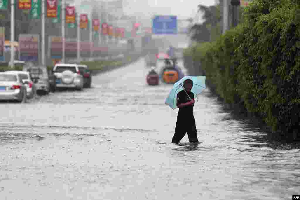 A man walks on a flooded street as typhoon Matmo made landfall, Jinjiang, Fujian province, China, July 23, 2014.
