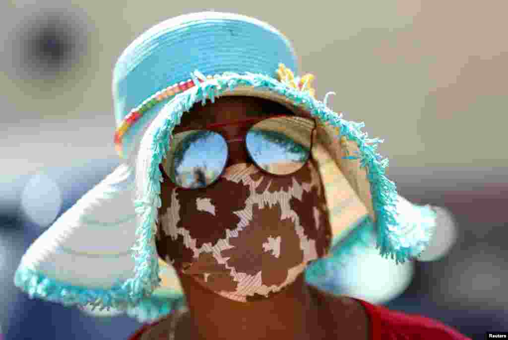 A woman wears a protective face mask during food distribution, as South Africa starts to relax some aspects of a stringent nationwide coronavirus disease (COVID-19) lockdown, in Diepsloot near Johannesburg.