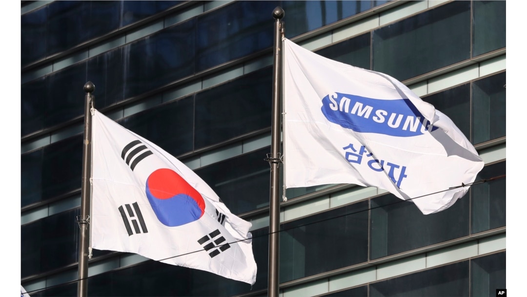 The company flag of Samsung Electronics (R) flutters next to the South Korean national flag in Seoul, South Korea, Jan. 16, 2017
