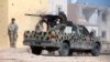 FILE - A member of Libyan forces allied with the U.N.-backed government fires a weapon on a pickup truck during a battle with Islamic State militants in Giza Bahreya, in Sirte, Libya, Oct. 27, 2016. 