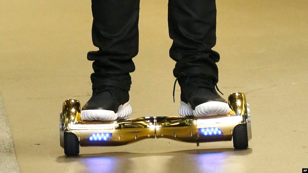 FILE - Seattle Seahawks wide receiver B.J. Daniels rides a hoverboard as he arrives for an NFL football game against the Carolina Panthers, in Seattle. Amazon is warning British customers that their hoverboards may be unsafe, the latest in a string of warnings about the popular scooters. 