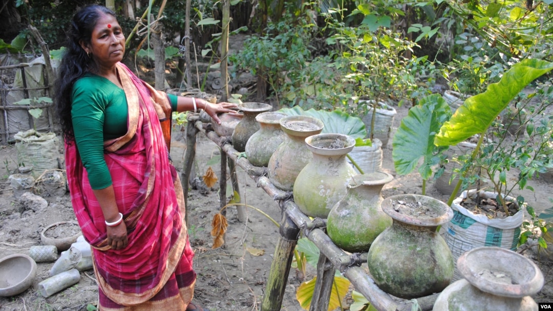 A woman in Chandipur village in southwest Bangladesh shows the pumpkins she grew in her "vertical garden." (Photo: A. Yee for VOA)