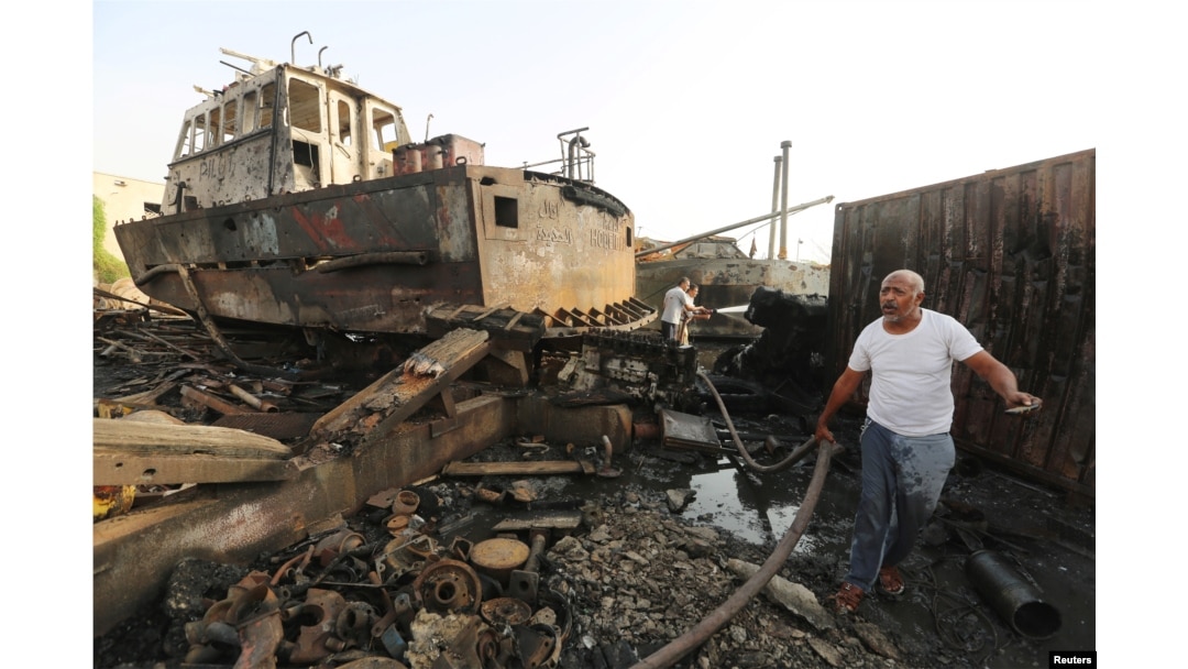FILE - Workers inspect damage at the site of an air strike on the maintenance hub at the Hodeida port, Yemen, May 27, 2018.