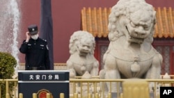 一名中國警察站在北京天安門前的石獅子旁。（2021年3月11日）