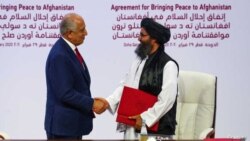 Mula Abdul Gani Garadar, lider talibanske delegacije i Zalmaj Halilzad, američki mirovni izaslanik u Avganistanu rukuju se posle potpisivanja sporazuma u Dohi u Kataru, 29. feburara 2020.
