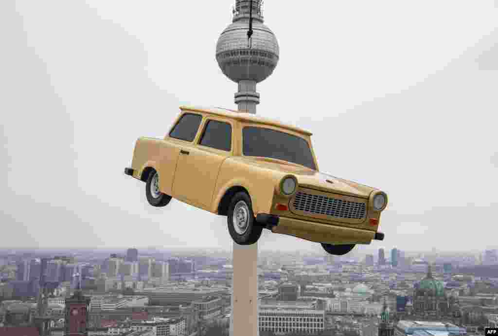 The likeness of a Trabant, east Germany's iconic car, is suspended over a Berlin skyline with its landmark the TV tower during a publicity stunt for an amusement park.