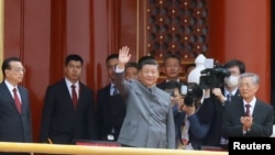 2021 年7 月1 日，在北京天安門廣場舉行的中國共產黨成立100 週年紀念活動結束時，中國國家主席習近平在李克強總理和前國家主席胡錦濤旁邊揮手致意。