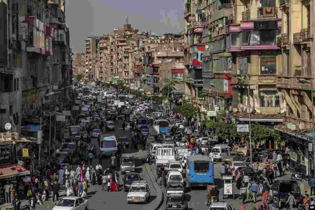 People crowd a street a few hours ahead of curfew in Cairo, Egypt. The government has imposed a nationwide curfew from 8 p.m. to 6 a.m due to the coronavirus outbreak.