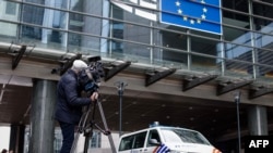 Журналист ведет съемку у здания Европарламента, где проходят обыски в рамках расследования в связи с информацией о российском вмешательстве. 29 мая 2024 г.