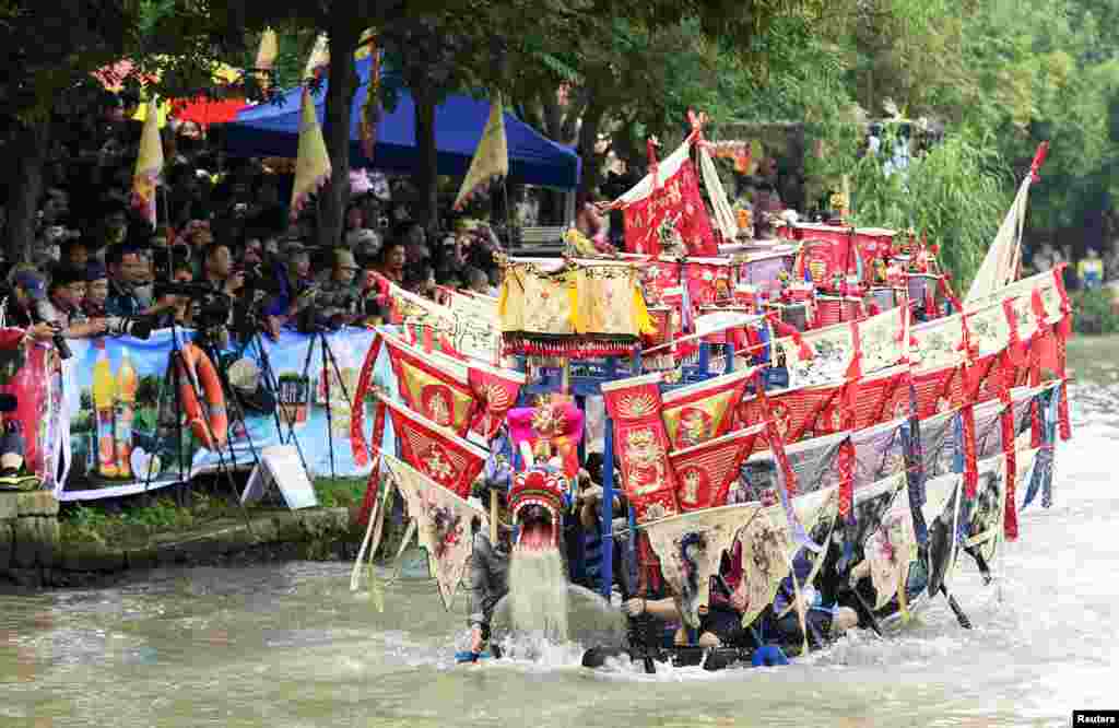 Participants paddle a dragon boat to celebrate the Dragon Boat Festival on a wetland in Hangzhou, Zhejiang province, China. The festival, which falls on June 12 this year, commemorates the memory of Chinese patriotic poet Qu Yuan, who drowned himself in 277 BC to protest against the corrupt government of his time.